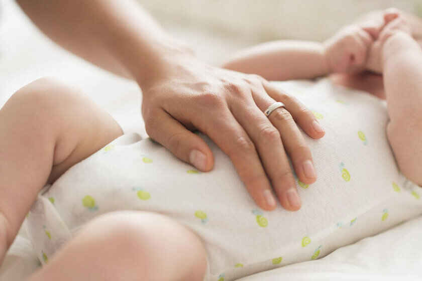 бебе и мама, която е сложила ръка на коремчето му. 