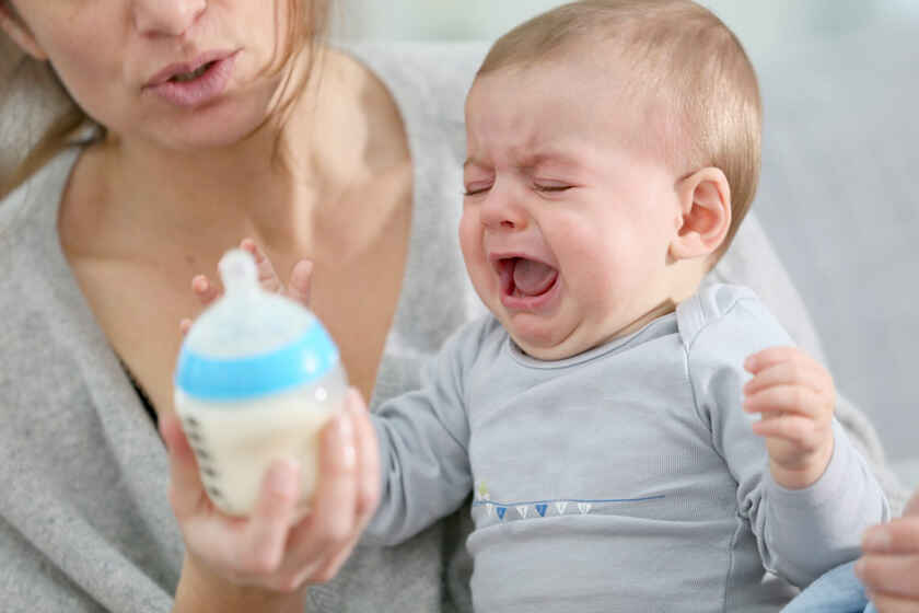 бебе с шише мляко, което плаче